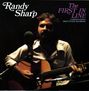 Text: "Randy Sharp" und "The First in Line". Ein Mann sitzt mit einer Gitarre vor einem Mikrofon, in sanftem Licht.
