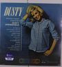 Text: "DUSTY", "America's newest singing star", "DUSTY SPRINGFIELD", Songtitel. Frau in blauem Hemd, lächelnd.