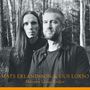"MATS ERLANDSSON & GUS LOXBO, Minnets Långa Kedjor". Zwei Personen im Wald bei schwarz-weißer Fotografie.