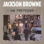 "JACKSON BROWNE" in großen Buchstaben, darunter "The Pretender". Menschen überqueren eine belebte Straße in einer Stadt.