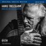 HANS THEESSINK ANALOG RETROSPECTIVE. Ein Mann hält eine Gitarre und schaut nachdenklich.