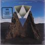 "Giraffe Tongue Orchestra - Broken Lines". Eine geometrische Illustration über einem Felsen in einer Landschaft.