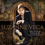 Der Text lautet: "SUZANNE VEGA, Tales From the Realm of the Queen of Pentacles". Eine Frau hockt vor einem dekorativen Hintergrund.