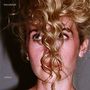 Text: "blondshell" oben links, "violins" unten links. Eine Frau mit lockigem, blondem Haar verdeckt teilweise ihr Gesicht.