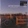 Text: "BOTTOM BRACKET I'M SO AFRAID OF WHERE". Ein Fahrrad lehnt an einem Holzzaun vor einer Landschaft mit Wachturm.