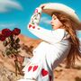 Keine Texte. Eine Frau mit Strohhut hält Rosen. Sie trägt einen weißen Anzug mit roten Herzmustern. Hintergrund ist eine Wüstenlandschaft.