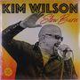 Texte: „KIM WILSON Slow Burn“. Ein Mann mit Sonnenbrille singt leidenschaftlich in ein Mikrofon.