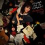 "Elizabeth and The Catapult, Responsible Friend". Eine Frau sitzt umgeben von Vinyl, Fotos, Kassetten und roten Schuhen.