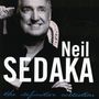 Text: Neil Sedaka, the definitive collection. Schwarz-weiß Foto eines lächelnden Mannes auf verziertem Stuhl.