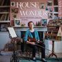 „House of Wonder“: Sally Beamish feiert 70 Jahre. Frau mit Geige, sitzend vor einem Kamin, umgeben von Fotos und Miniaturen.