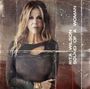 "RITA WILSON SOUND OF A WOMAN." Frau mit langen Haaren in einem dunklen Outfit vor einem abgenutzten Hintergrund.