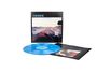 Text: "HOWE - CONFLUENCE". Ein blaues Vinyl, Albumcover mit Hand am Lenkrad, Wüstenlandschaft im Hintergrund.