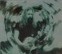Keine Texte erkennbar. Ein Mann mit langen Haaren spielt Gitarre, umgeben von einem verschwommenen Wirbeleffekt.
