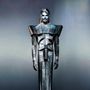 Ich kann keine Texte oder spezifischen Details erkennen. Eine Figur in futuristischer, metallischer Rüstung mit strengen Linien.