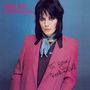JOAN JETT and the blackhearts; I love Rock-n-Roll. Frau mit schwarzem Haar in rosa Jacke vor blauem Hintergrund.