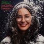 "Alanis Morissette. Good Weather For Immaculate Conception" in grüner und roter Schrift. Frau mit Brille und Schnee auf Jacke.