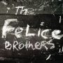 Die Wörter "The Felice Brothers" sind in weißer Kreideschrift auf einer dunklen, strukturierten Oberfläche.