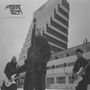 „Molchat Doma Live at Panorama Hotel“. Drei Musiker mit Gitarren vor einem modernen, mehrstöckigen Gebäude.