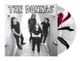 Text: "THE DONNAS". Vier Frauen in Schwarz posieren in einem engen Gang. Eine Schallplatte mit rotem und schwarzem Design.