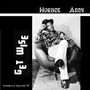 „Horace Andy – Get Wise“. Schwarz-Weiß-Foto: Mann in Hut und gemustertem Hemd sitzt lässig in einem Sessel.