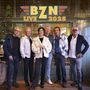 "BZN Live 2025" steht oben. Sechs Personen in stilvoller Kleidung posieren vor einer dekorativen Wand.