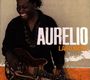 Text: Aurelio, Laru Beya. Ein Mann lacht, hält eine Gitarre, Hintergrund in Beige und Orange.