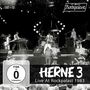 HERNE 3 Live At Rockpalast 1983. FSK ab 0 freigegeben. Schwarze Bühne, Band spielt, Publikum im Vordergrund, Kameras filmen.