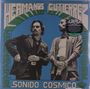 "HERMANOS GUTIERREZ", "SONIDO COSMICO". Zwei Männer in Anzügen vor blauem Hintergrund, retro Stil.