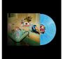 Blaues Vinyl mit Foto: Eine Frau mit blauen Haaren und Kopfhörern im Bad, umgeben von bunten Gegenständen.