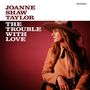 Text: "Joanne Shaw Taylor, The Trouble with Love." Frau mit Hut und Gitarre auf rotem Hintergrund.