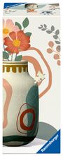 "3D Puzzle" und "Ravensburger" sind sichtbar. Eine Illustration zeigt farbige Blumen und eine Vase mit Puzzle-Optik.