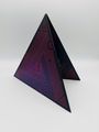 Schwarzes dreieckiges Objekt mit rosa Linienmuster und eingebetteten Kreisformen, geometrisches Design.