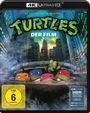 "TURTLES DER FILM", vier maskierte Schildkröten tauchen aus einem Kanaldeckel auf, umgeben von Wolkenkratzern.