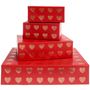 Rote Geschenkboxen in einem Stapel, bedeckt mit goldenen Herzmustern.