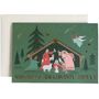 "Merry Christmas," "Frohe Weihnachten," "Joyeux Noël" unter einer Illustration der Krippenszene mit Tieren und einem Engel.