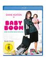 Text oben: "DIANE KEATON IN BABY BOOM". Darunter: "EINE SCHÖNE BESCHERUNG". Frau mit Kind, Umhängetasche und offenem Aktenkoffer.