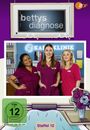 "bettys diagnose" in einem Schild, "STAFFEL 12" unten. Drei Frauen in lila Krankenhauskleidung, lächelnd vor Klinikbüchern.