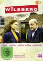 "WILSBERG", "WAHNSINN", FSK 12, "Mogelpackung", "Tödlicher Tipp". Zwei Personen stehen vor einem Backsteingebäude.