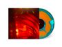 Ein Mann in rotem Lichtschein und Nebel. Vinyl in Orange und Blau mit schwarzem Zentrum. Erscheinung von Bewegung und Farben.