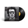Text: "Joe Strummer 003: The 101'ers Years 1974-1976". 
Ein Schwarz-Weiß-Foto eines Mannes mit Sonnenbrille. Vinyl daneben.