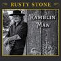 Text: "RUSTY STONE" oben, "RAMBLIN 'MAN" rechts. Schwarz-weißes Foto eines Mannes mit Gitarre an einem Baum.