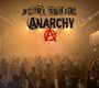 Oben steht "Harri Stojka". Darunter groß "ANARCHY" mit einem roten Anarchie-Symbol. Menschenmenge vor Bühne.