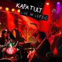 Text: "Kapa Tult Live in Leipzig". Eine Band spielt auf einer Bühne mit bunten Lichtern.
