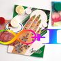 "Silky Hand 3" und "Saachi" in geschwungener Schrift. Hand mit Juwelen verziert, bunte geometrische Formen und Kreise.