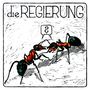 Text: "die REGIERUNG". Zwei Ameisen kommunizieren mit einem Sprechblasen-Symbol in Form eines Fragezeichens. Illustratorischer Stil.