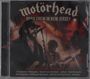 „Motörhead“, „Road Crew in New Jersey“, Musiker auf einer Bühne mit Mikrophon und Gitarre, rockige Atmosphäre.