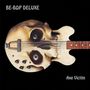 Oben links steht "BE-BOP DELUXE", unten rechts "Axe Victim". Es zeigt eine Gitarre in Form eines Schädels.