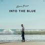 "Aaron Frazer INTO THE BLUE" steht oben. Ein Mann steht am Strand, schaut zurück, das Meer im Hintergrund.