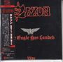 "Saxon - The Eagle Has Landed" in roten Buchstaben auf schwarzem Hintergrund, mittig Adler-Emblem. Japanische Schriftzeichen links.