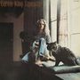 Text: "Carole King Tapestry". Frau sitzt entspannt neben einem großen Fenster, eine Katze sitzt daneben.